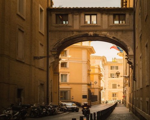 A quiet residential street in Rome bathed in warm afternoon sunlight